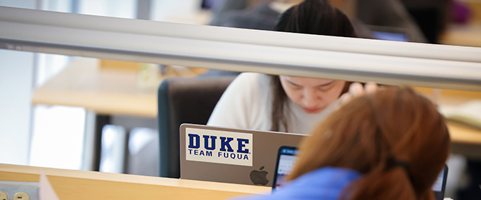 Student on laptop at Duke University's Fuqua School of Business